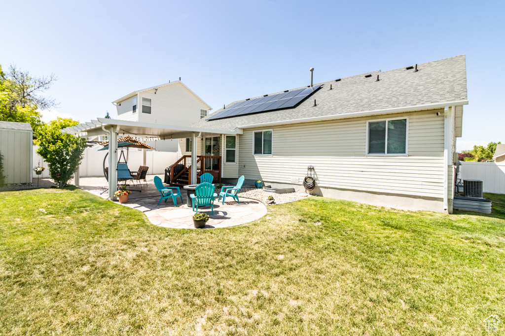 Rear view of property with a patio, solar panels, a pergola, and roof with shingles