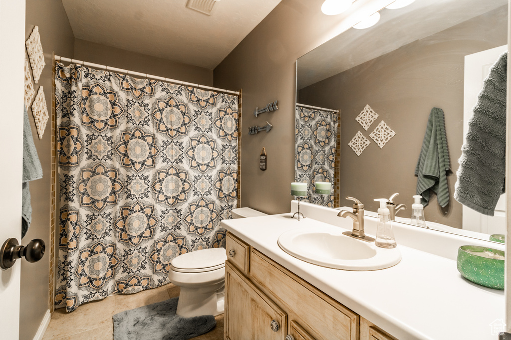 Full bath featuring vanity, toilet, tile patterned floors, and curtained shower