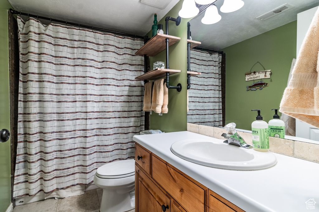 Full bathroom with vanity, toilet, and a shower with curtain