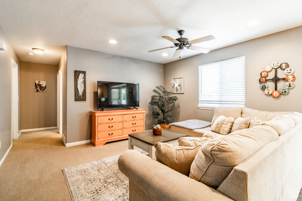 Living area with a ceiling fan, light colored carpet, baseboards, and recessed lighting
