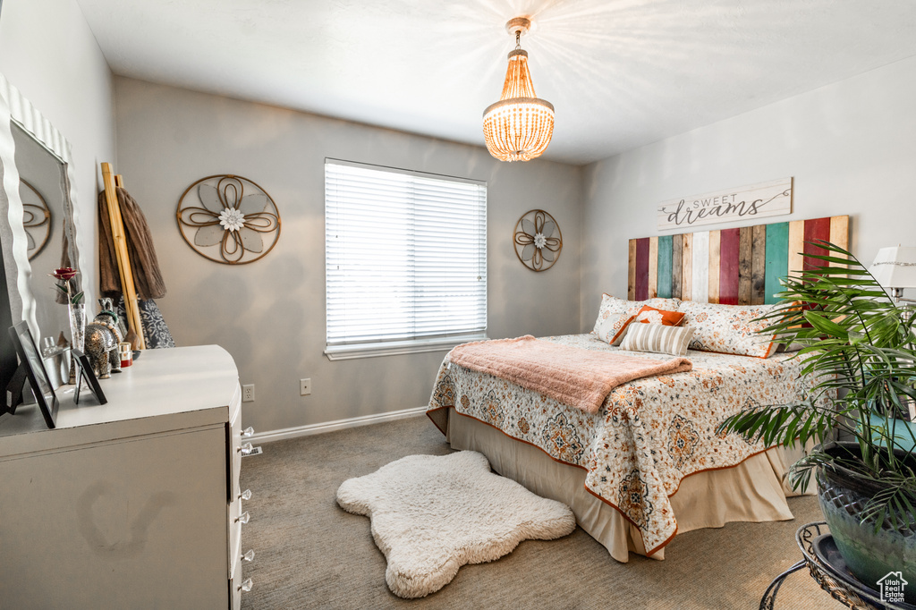 Bedroom with carpet floors, a chandelier, and baseboards