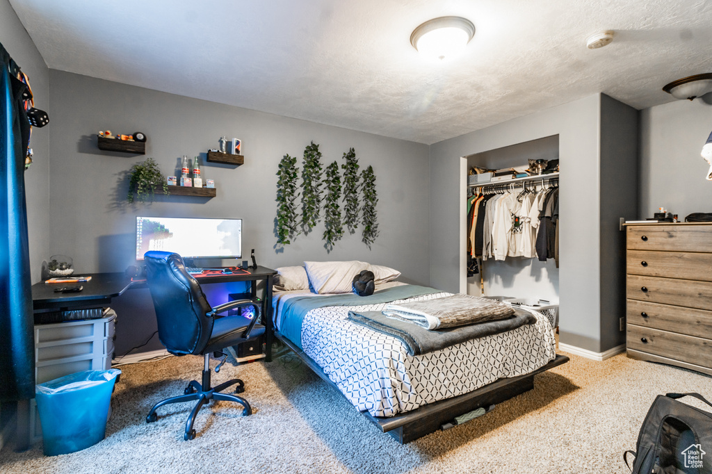Carpeted bedroom with a closet and baseboards