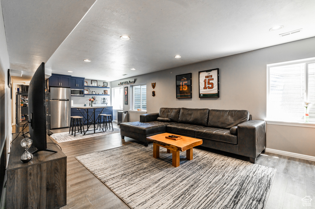 Living room featuring light wood-style floors, recessed lighting, and baseboards