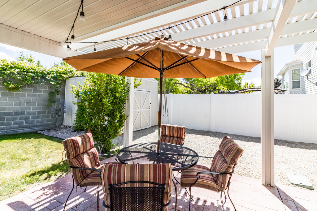 Fenced backyard featuring outdoor dining space, a patio area, and a pergola
