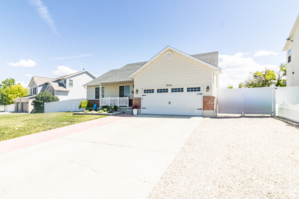 View of front of property with brick siding, an attached garage, driveway, and covered porch