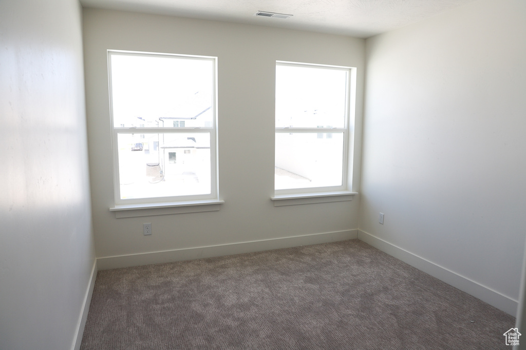 Spare room featuring carpet and baseboards