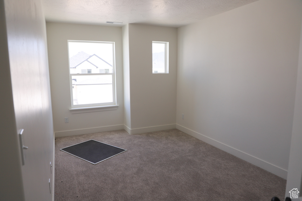 Unfurnished room featuring light carpet and baseboards