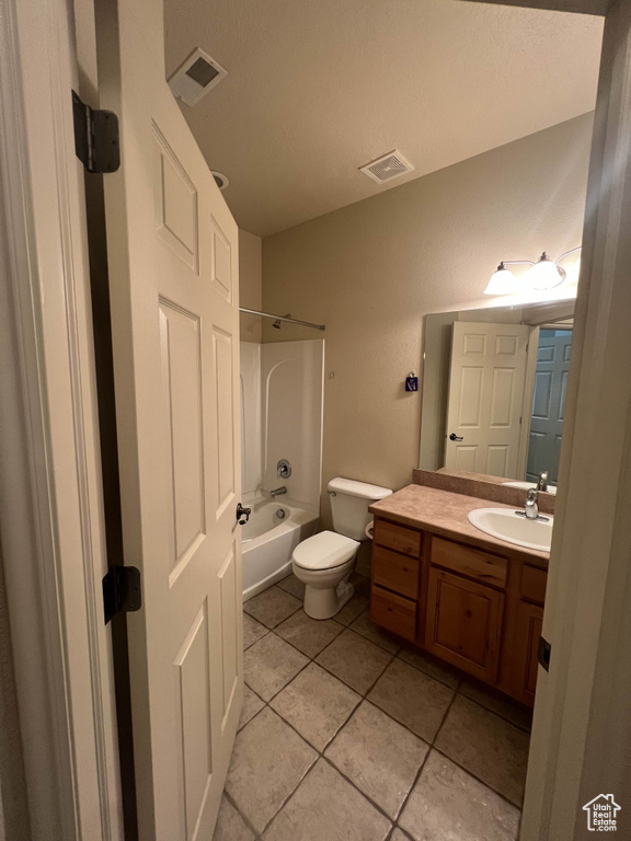 Bathroom with vanity, tile patterned flooring, shower / bath combination, and toilet