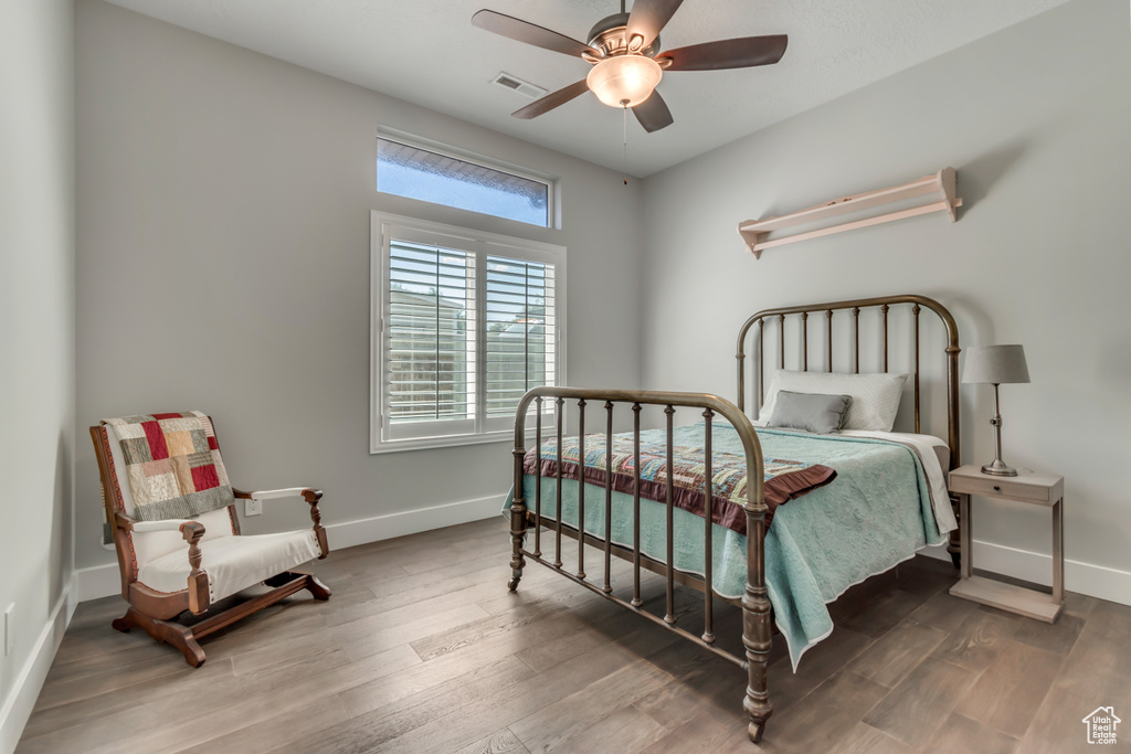 Bedroom featuring wood finished floors, baseboards, and a ceiling fan