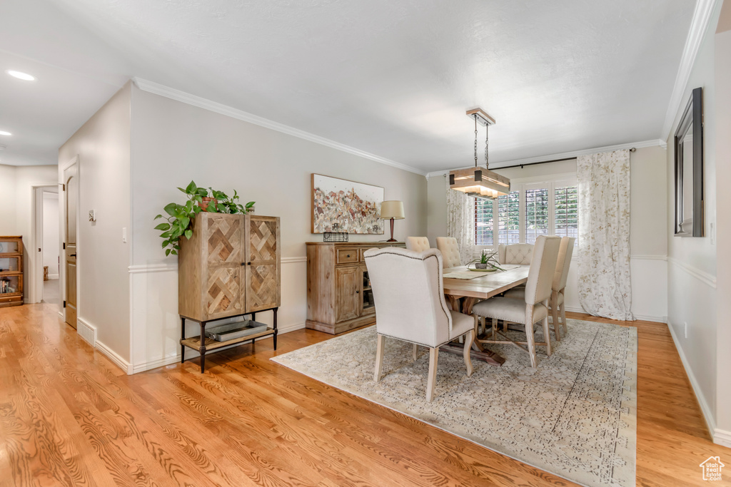 Dining space featuring light wood-type flooring, baseboards, ornamental molding, and recessed lighting
