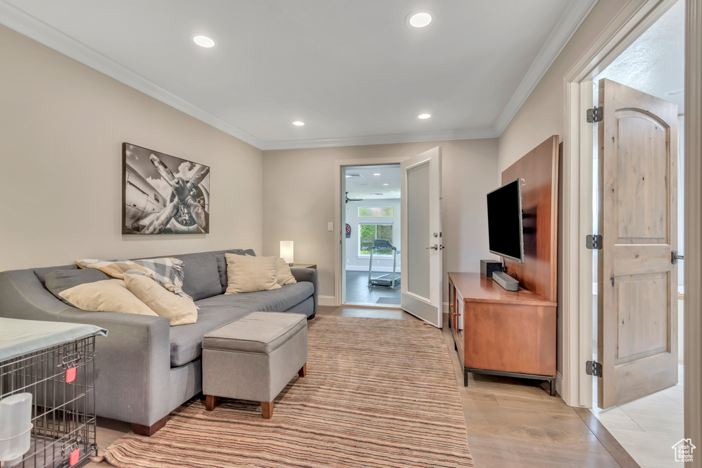 Living room with recessed lighting, crown molding, light wood finished floors, and baseboards