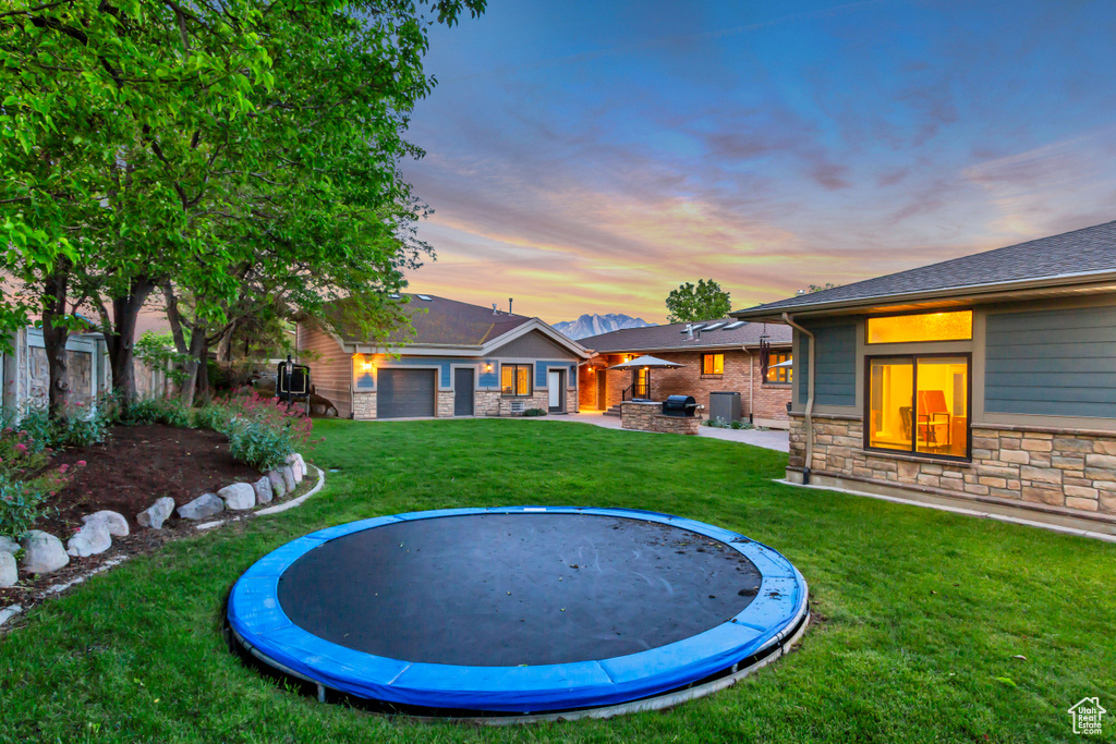 View of yard with a trampoline and a patio