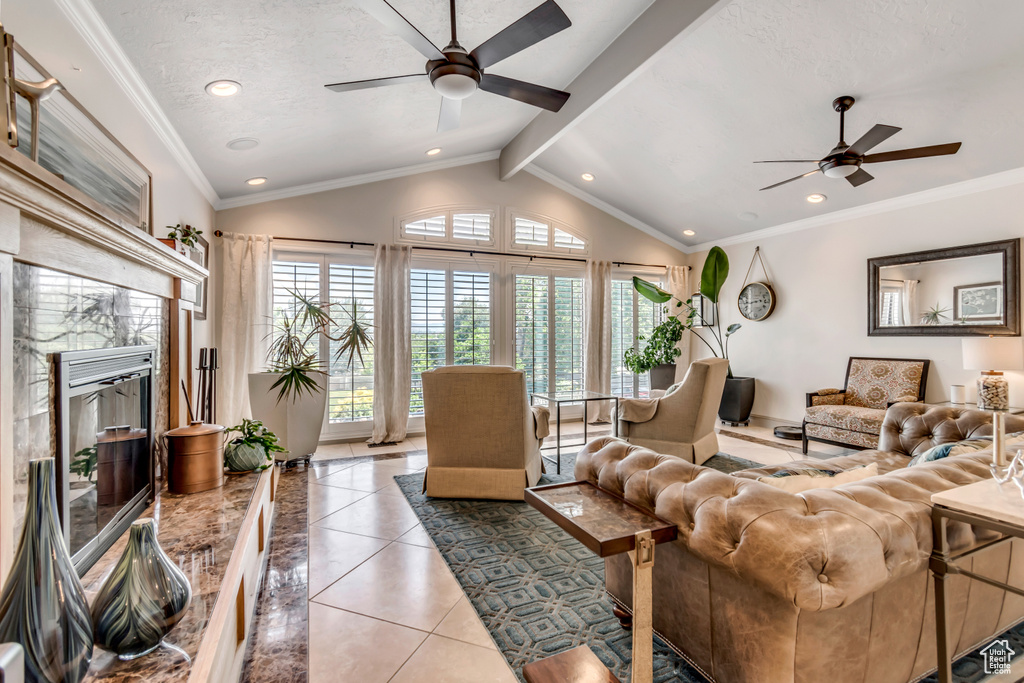 Living area with a ceiling fan, a premium fireplace, recessed lighting, light tile patterned flooring, and crown molding