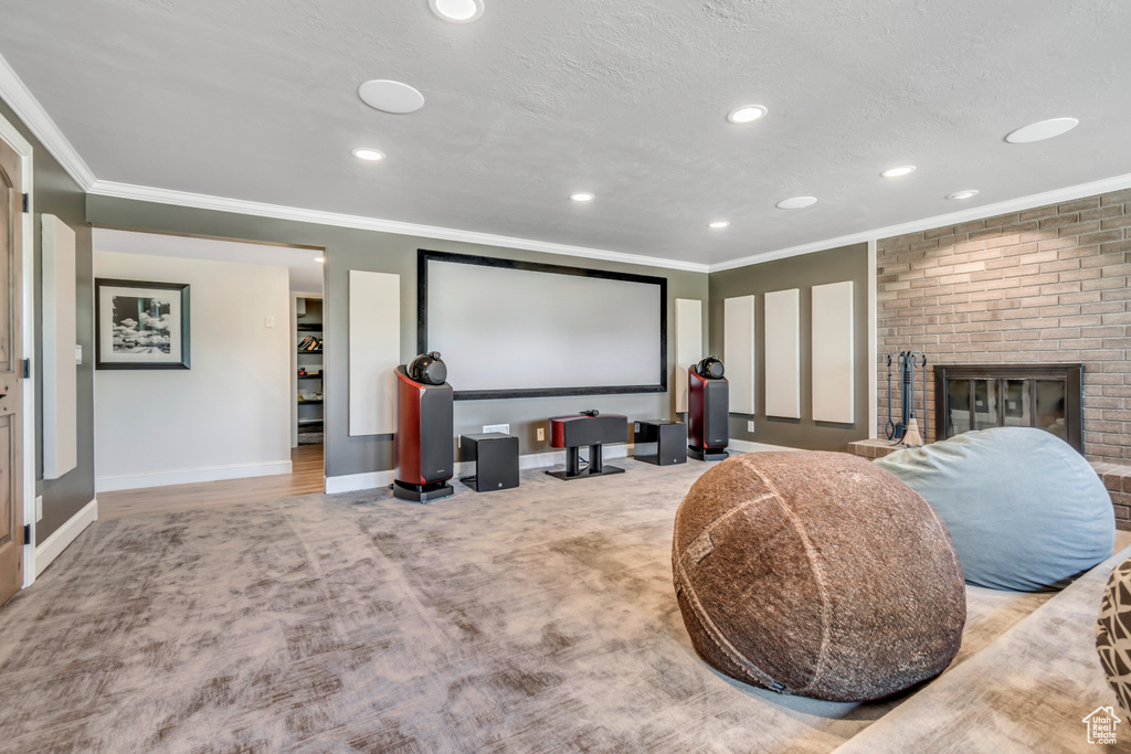 Cinema with recessed lighting, ornamental molding, baseboards, a fireplace, and carpet