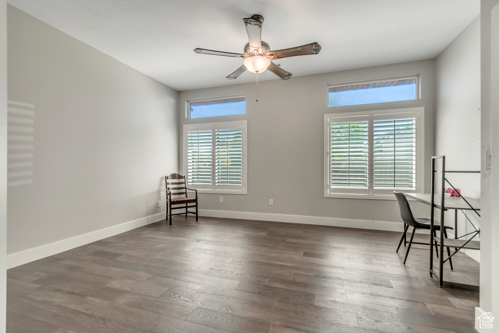 Unfurnished room with a ceiling fan, wood finished floors, and baseboards