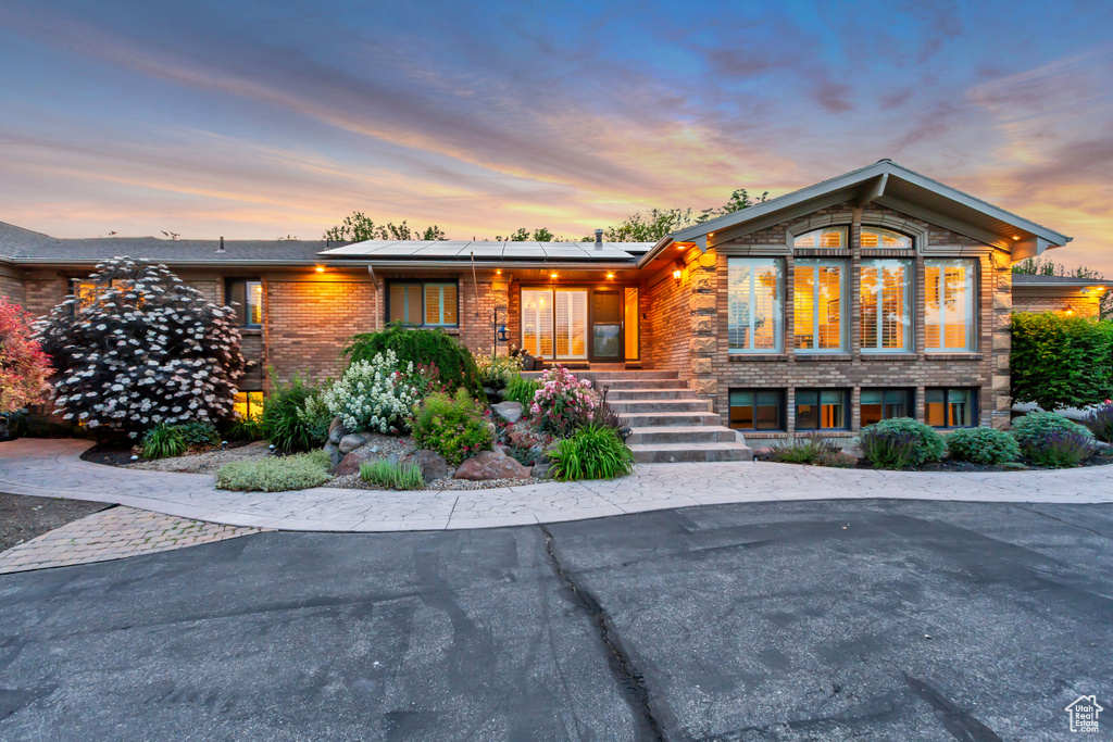 View of front of house with brick siding and roof mounted solar panels