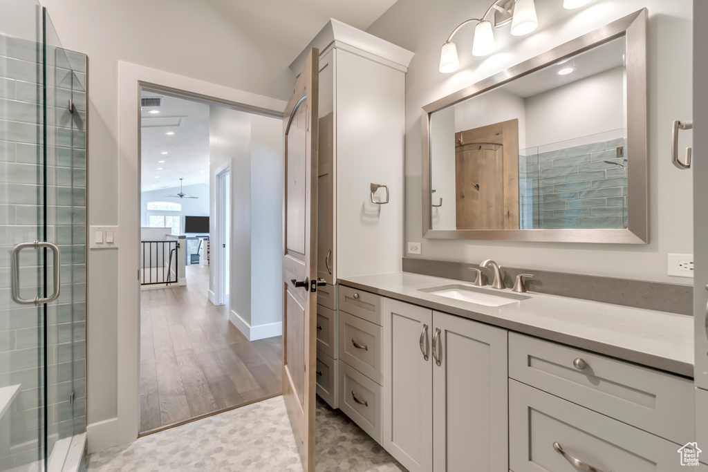 Bathroom featuring vanity, a shower with door, and recessed lighting