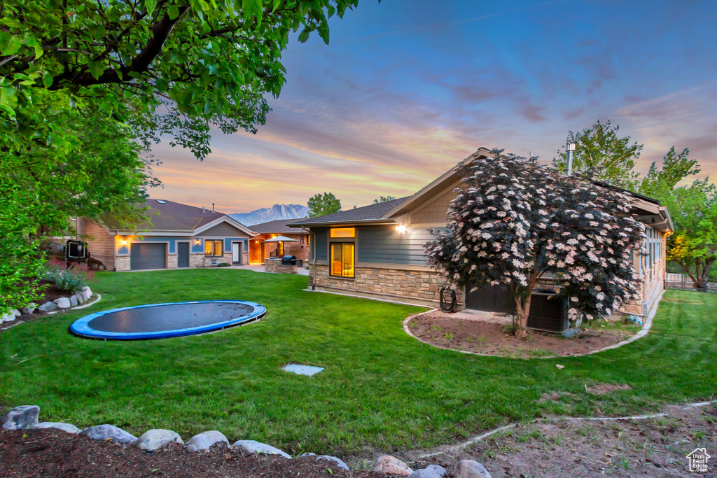 View of green lawn featuring a trampoline and central AC unit