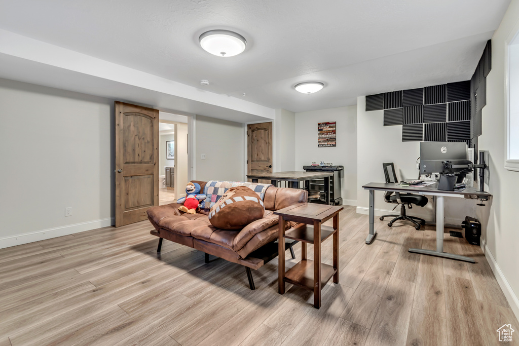 Living area featuring an office area, light wood finished floors, and baseboards