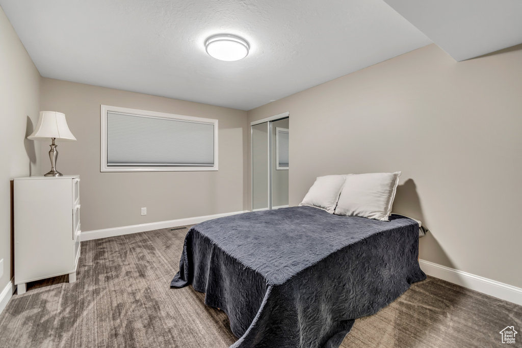 Bedroom featuring baseboards, a closet, and carpet flooring