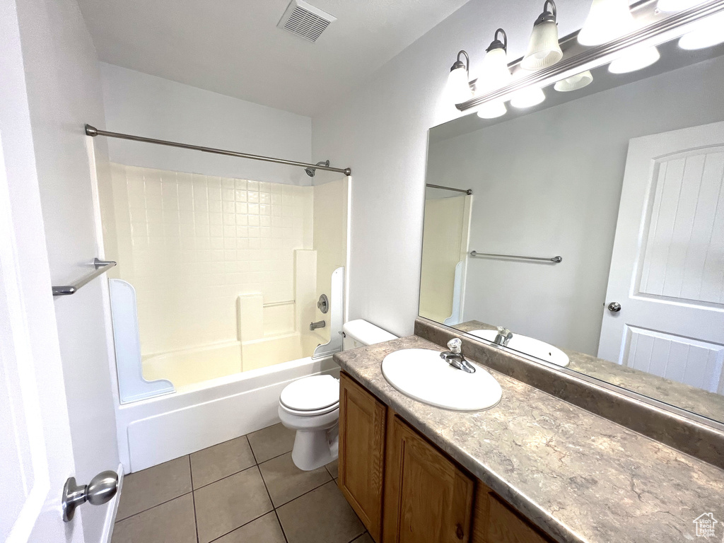 Bathroom with tile patterned floors, vanity, bathtub / shower combination, and toilet