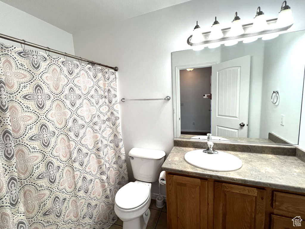 Full bathroom featuring vanity, toilet, curtained shower, and tile patterned flooring