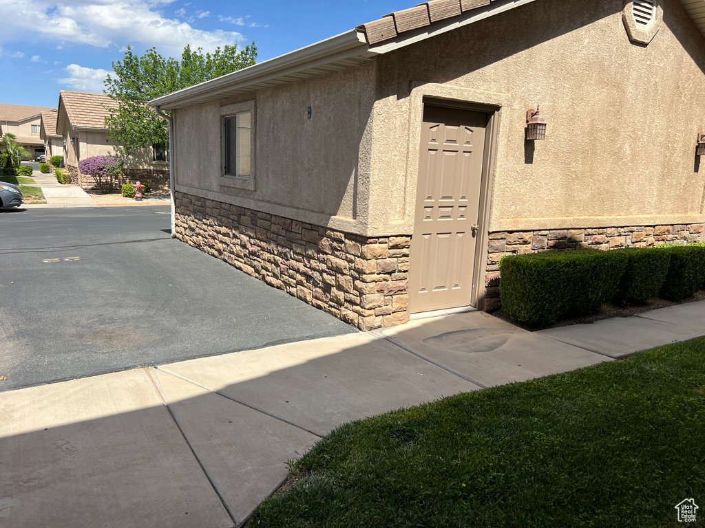 Entrance to property featuring stone siding and stucco siding