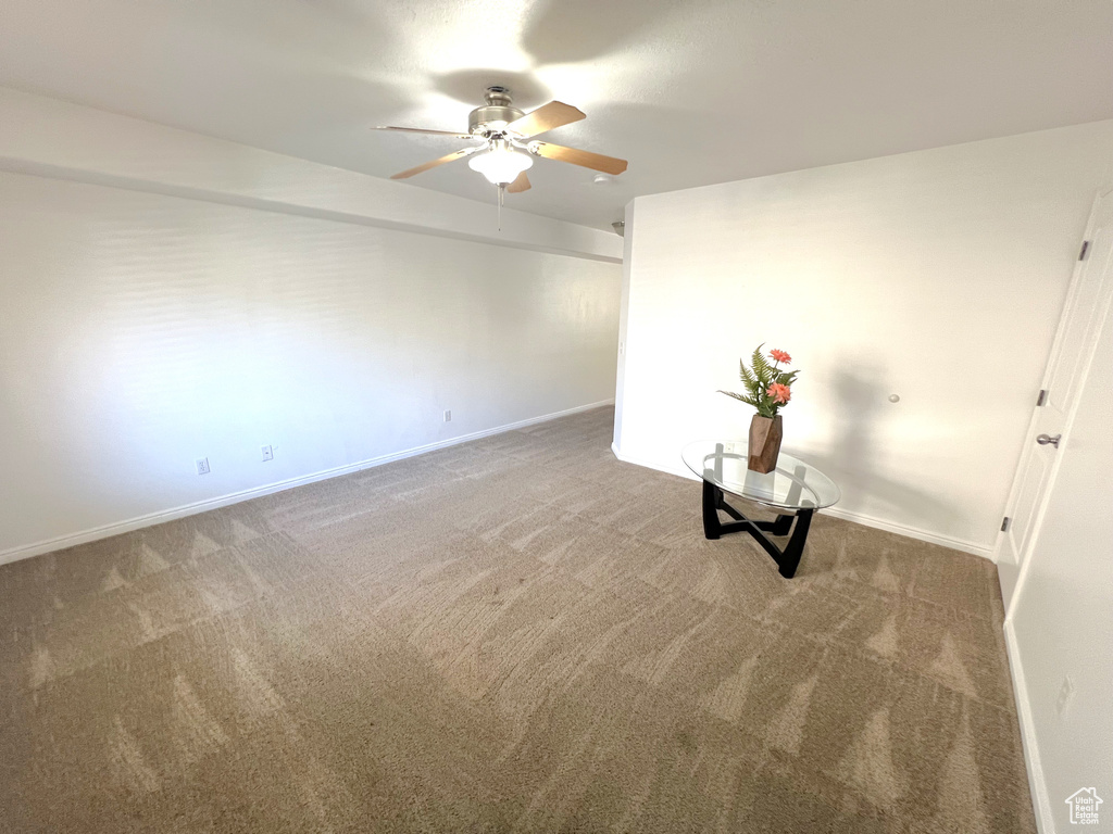 Unfurnished room featuring a ceiling fan, carpet floors, and baseboards