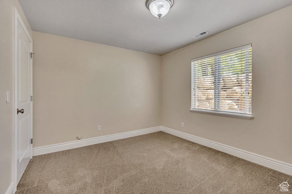 Carpeted empty room with baseboards
