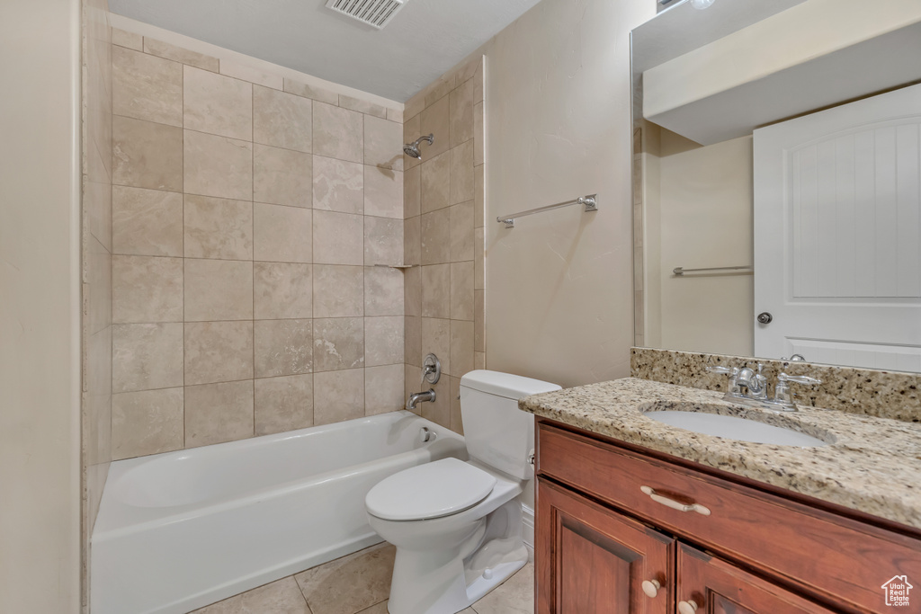 Bathroom featuring toilet, vanity, shower / washtub combination, and tile patterned floors