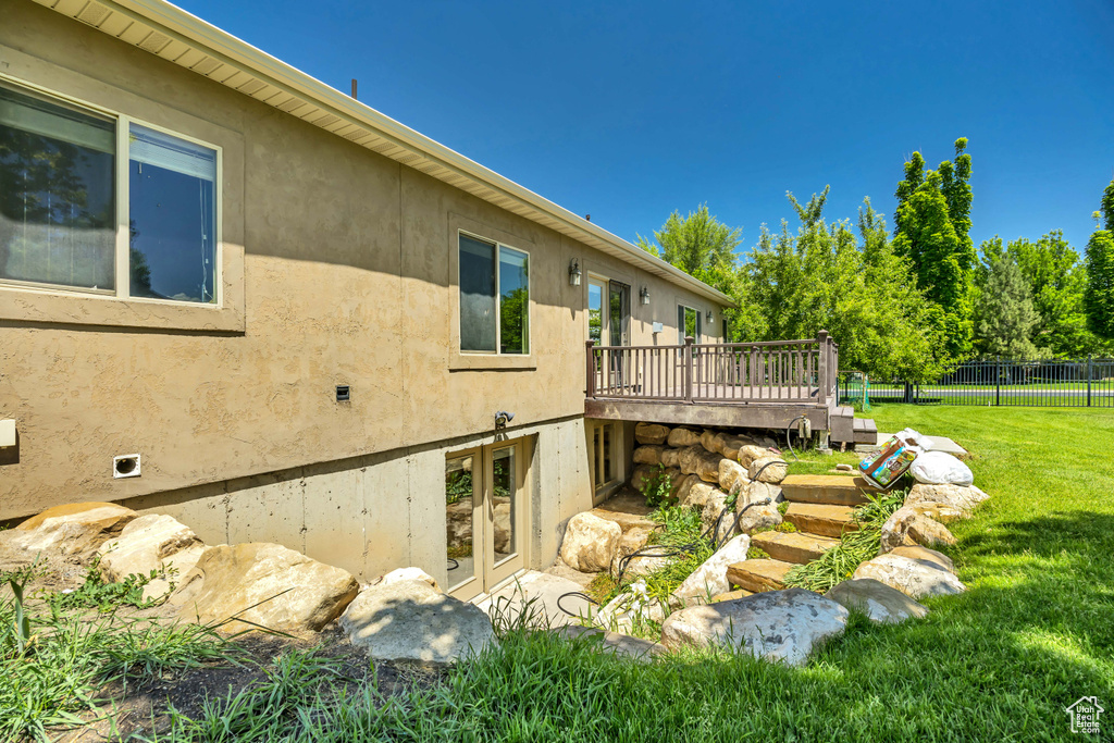 View of yard featuring a wooden deck and french doors