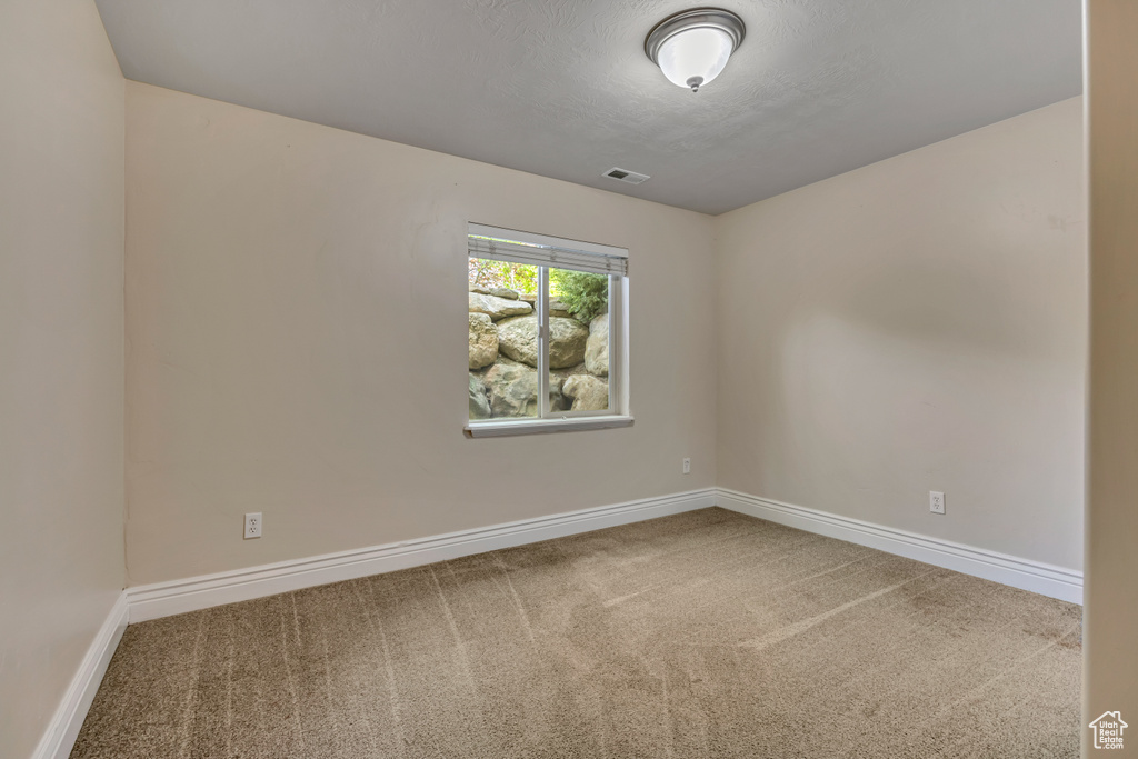 Carpeted empty room with baseboards