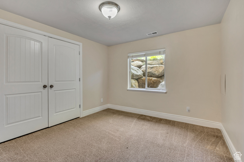 Unfurnished bedroom featuring carpet, baseboards, and a closet