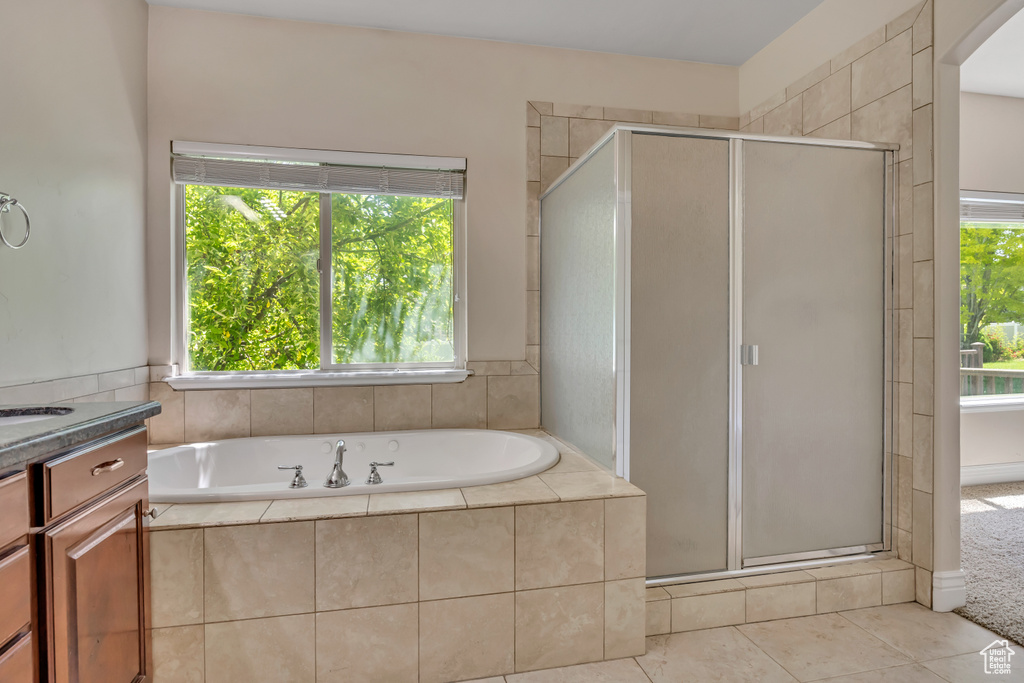 Full bath featuring a stall shower, vanity, healthy amount of natural light, and a bath