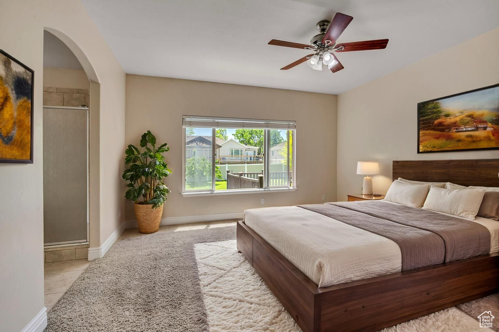Bedroom featuring arched walkways, baseboards, and ceiling fan