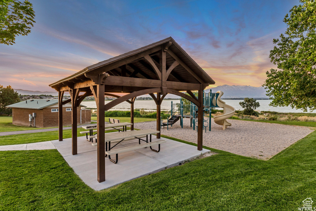 View of community featuring a lawn, a gazebo, a playground, and a water view