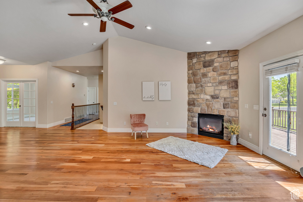 Unfurnished living room with healthy amount of natural light, lofted ceiling, a ceiling fan, light wood-type flooring, and recessed lighting