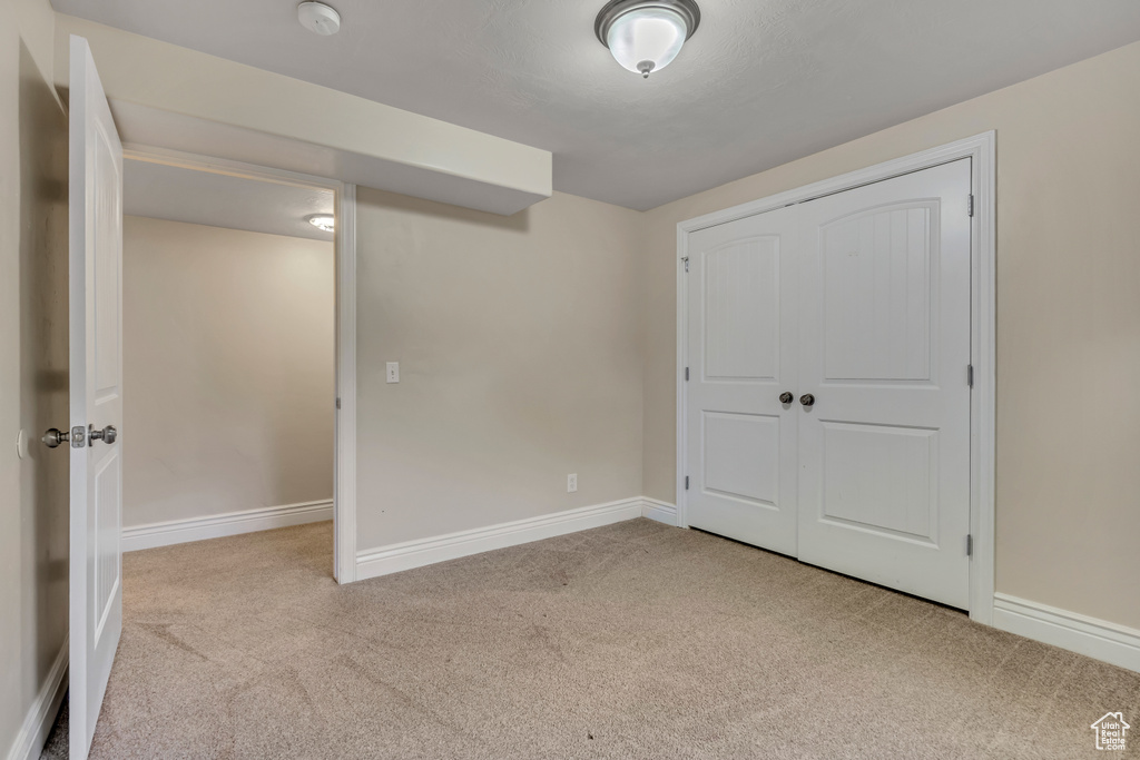 Unfurnished bedroom with carpet flooring, baseboards, and a closet