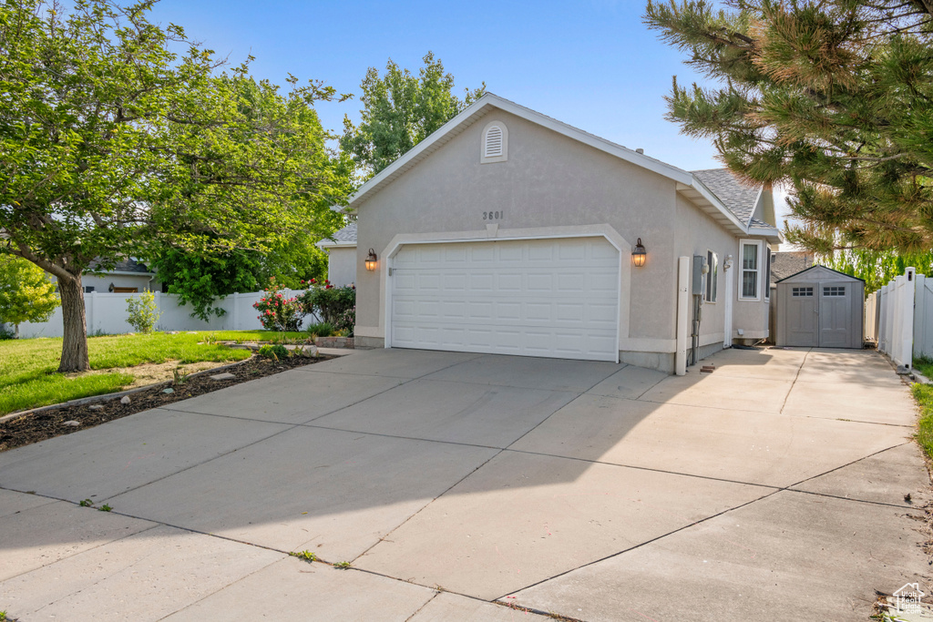 View of front of house featuring a garage, stucco siding, and concrete driveway