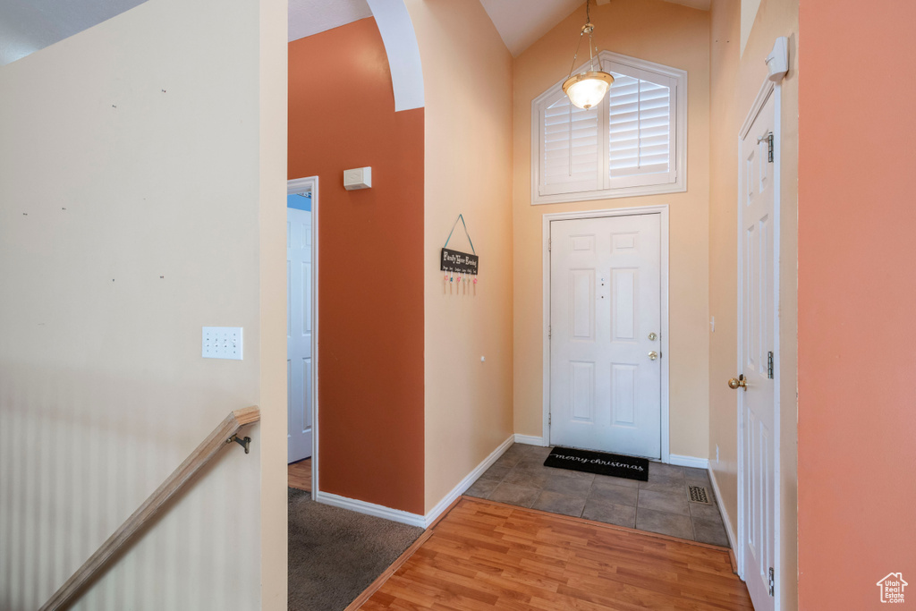 Foyer entrance with arched walkways, wood finished floors, and baseboards