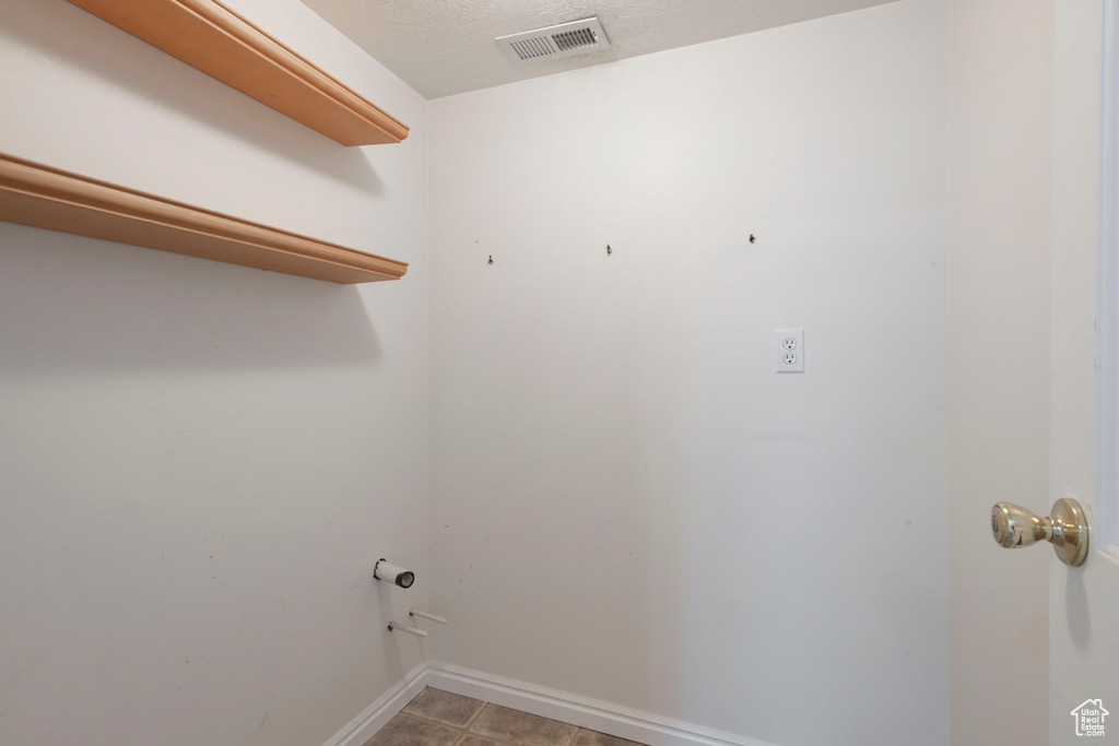 Washroom with baseboards and light tile patterned floors