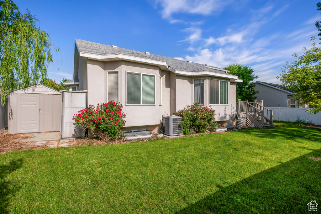 Back of property with stucco siding and central air condition unit