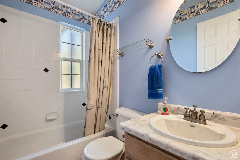 Full bath featuring shower / tub combo with curtain, toilet, and vanity