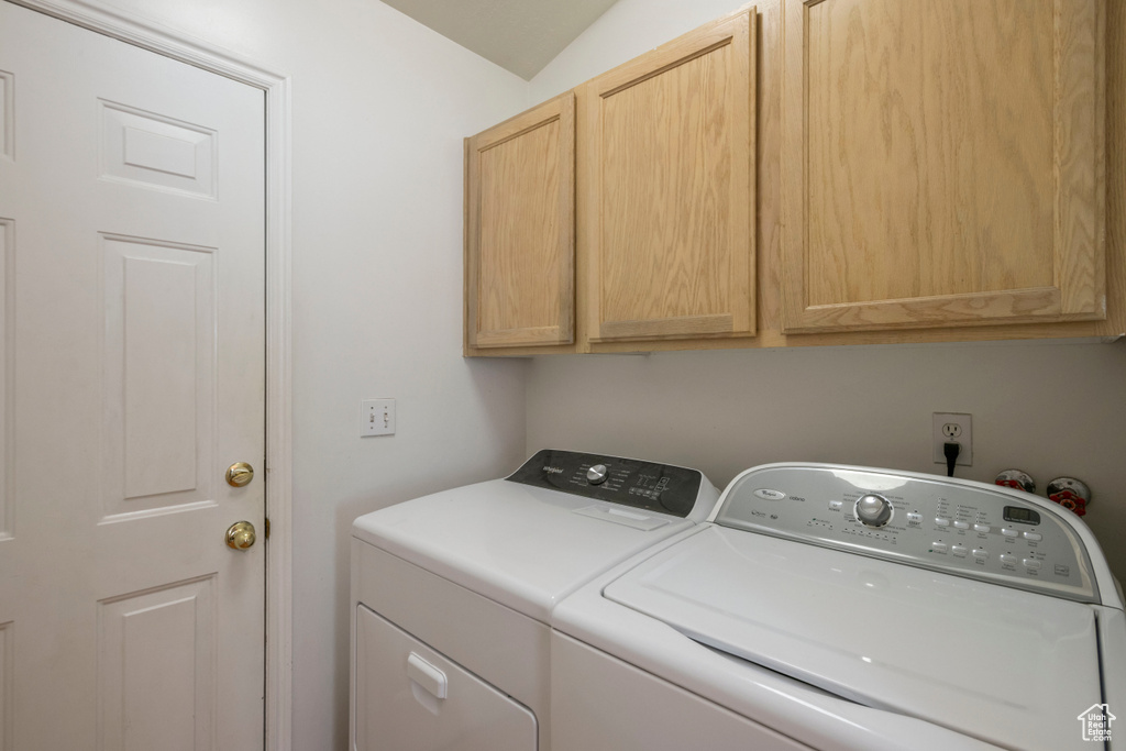 Laundry room featuring separate washer and dryer and cabinet space