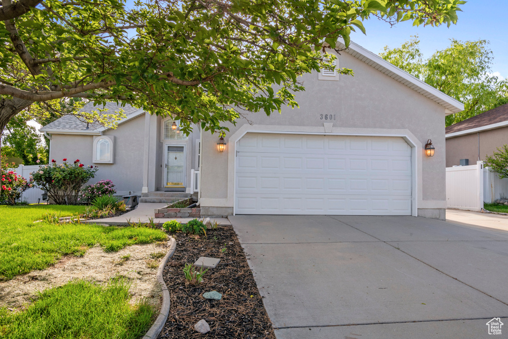 View of front facade with concrete driveway, a garage, and stucco siding
