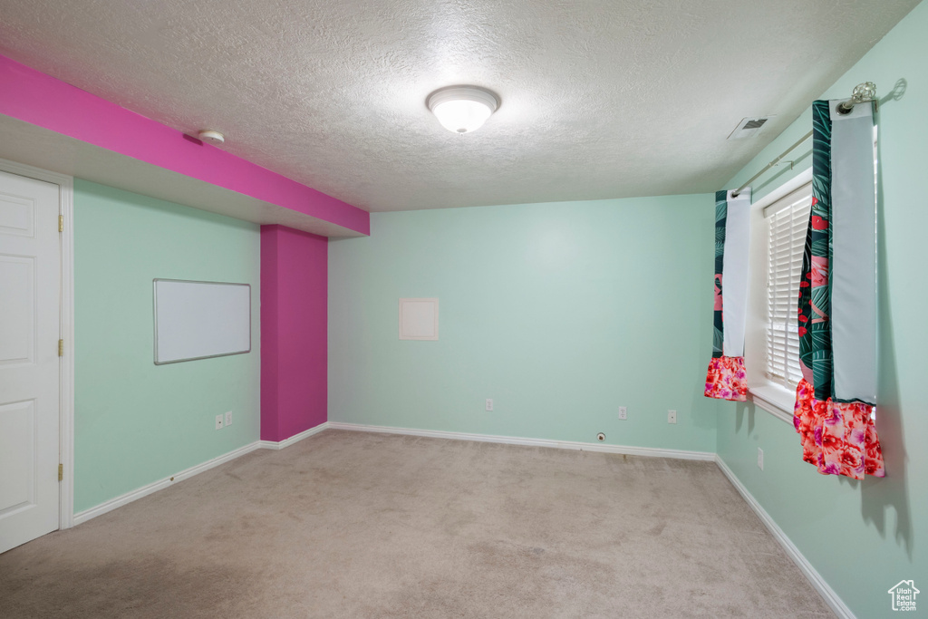 Unfurnished bedroom featuring a textured ceiling, carpet flooring, and baseboards