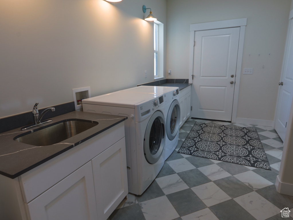 Laundry room with washing machine and clothes dryer, cabinet space, and light floors