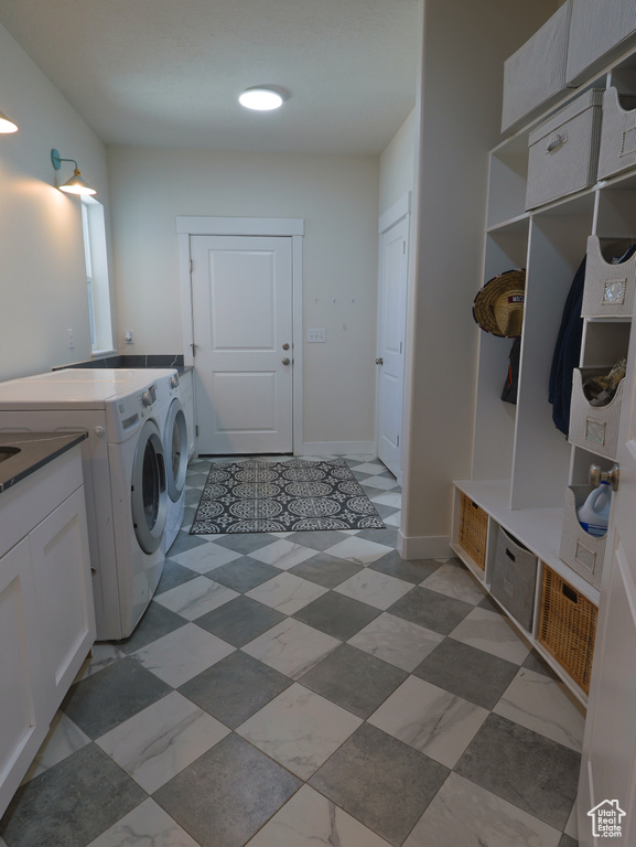Laundry area featuring washer and clothes dryer and cabinet space