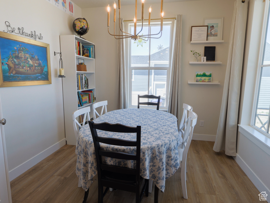 Dining area featuring a chandelier, wood finished floors, and baseboards