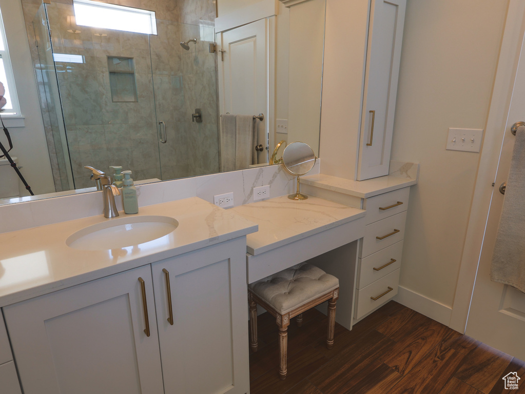 Full bath with wood finished floors, vanity, and a shower stall